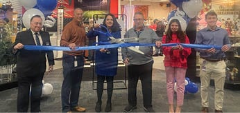 A group of people are cutting a ribbon in front of a store. AI generated content