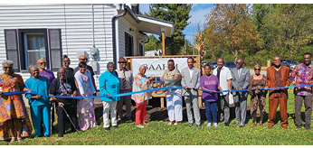 A group of people are standing in front of a house, holding a blue ribbon. AI generated content