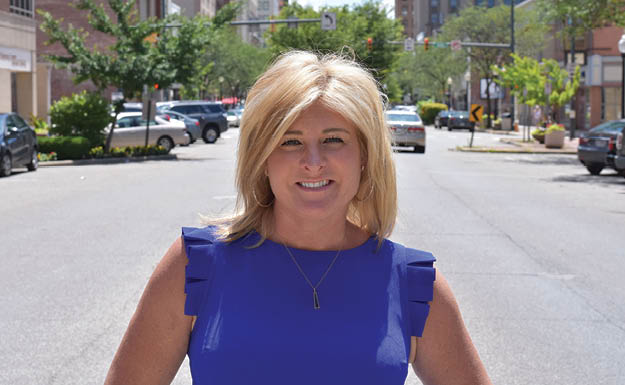 A woman in a blue dress is standing on a city street. AI generated content