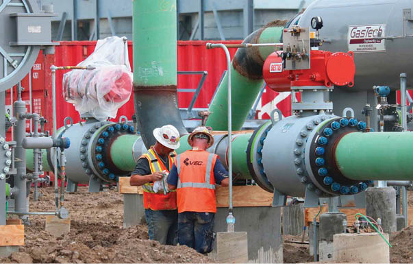 Two men are working on a pipe. One man is wearing a hard hat and an orange vest. AI generated content