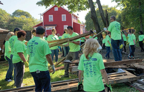 A group of people wearing green shirts are working together to build a structure. AI generated content