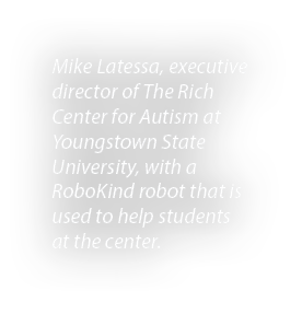 Mike Latessa, executive director of The Rich Center for Autism at Youngstown State University, with a RoboKind robot ...