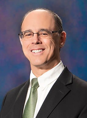 A man wearing a suit and tie. Description generated by AI