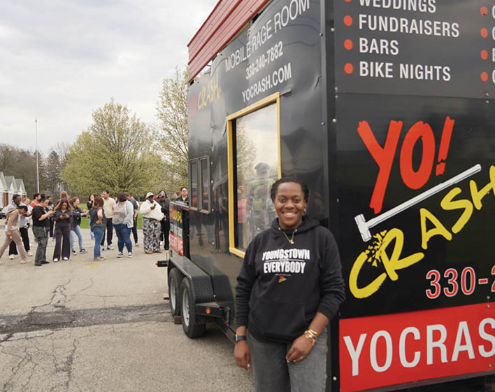 A woman is standing in front of a food truck. Description generated by AI