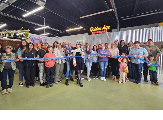 A group of people standing in front of a ribbon. Description generated by AI