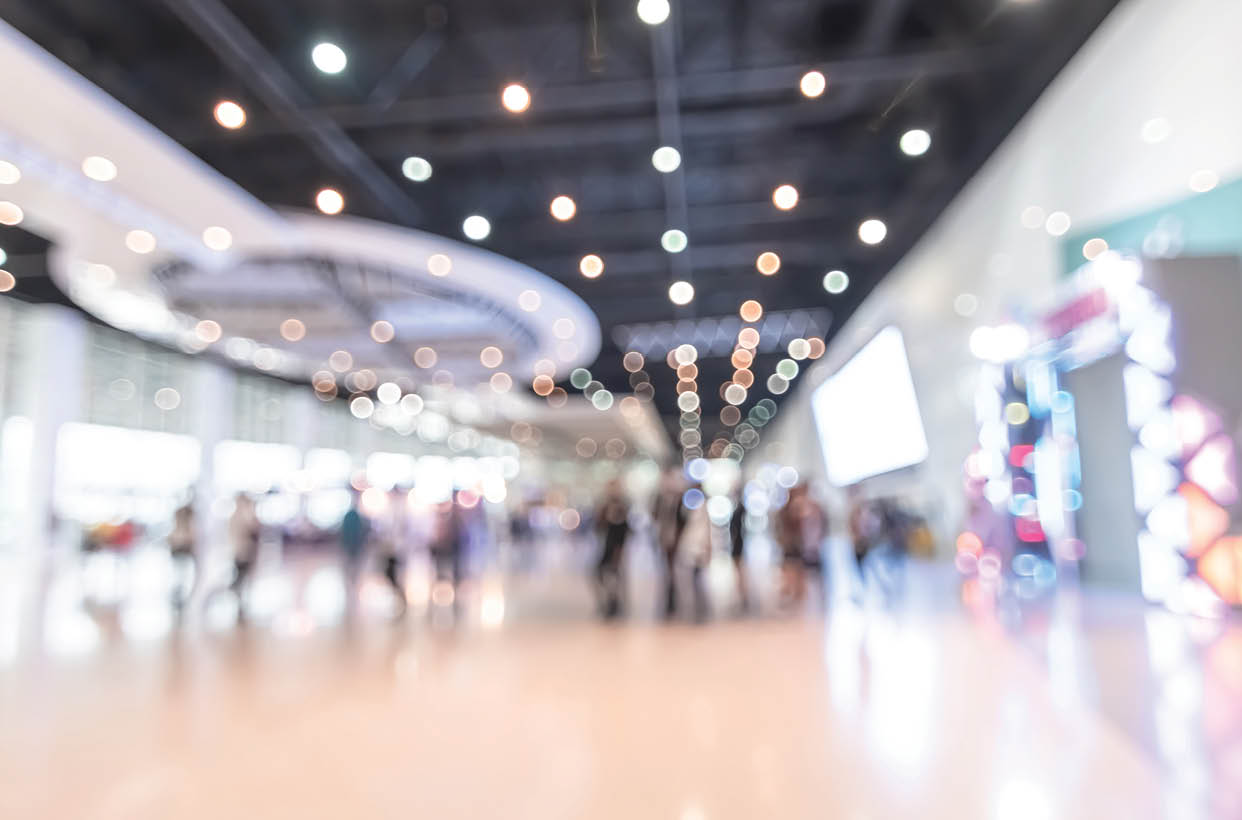 Exhibition event hall blur background of trade show business, world or international expo showcase, tech fair, with blurry exhibitor tradeshow booth displaying product with people crowd